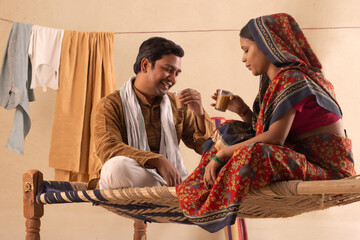 A HAPPY RURAL COUPLE SITTING AND DRINKING TEA TOGETHER