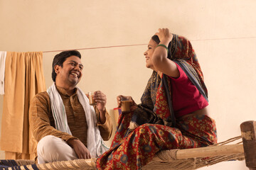 A RURAL COUPLE HAPPILY DRINKING TEA TOGETHER