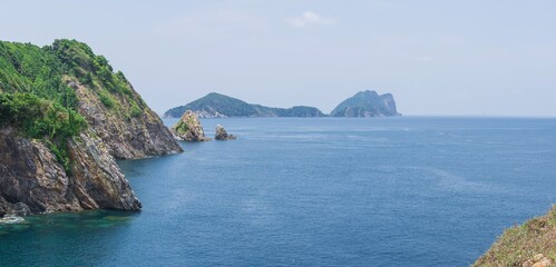 Fototapeta premium Tropical beach and Island with with mountain view, green ocean and clear seawater, Ariel high view from the mountain 360 degree. Ranong, Thailand