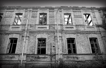 An abandoned dilapidated brick building. Black and white photo.