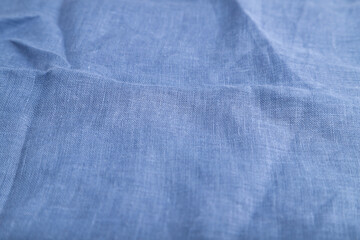 Fragment of smooth blue linen tissue. Side view, natural textile background.