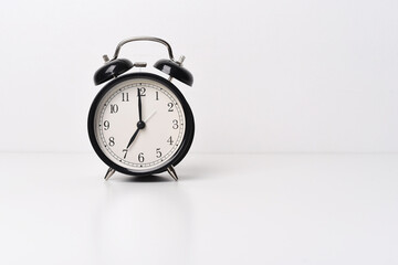 Black alarm clock on white (light) background