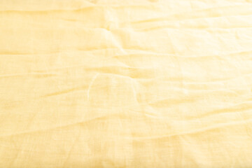 Fototapeta na wymiar Fragment of smooth yellow linen tissue. Side view, natural textile background.