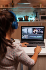 Filmmaker editing video footage in home using modern technology. Content creator in home working on...