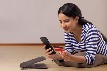 A young woman with laptop and credit card shopping online. 