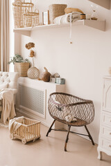 Children's wicker bed for babies in the interior of the children's room in light beige tones in the...