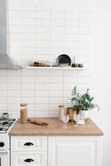 Bright kitchen in the Scandinavian style. Pasta in a glass jar, houseplant, glasses and kitchen utensils
