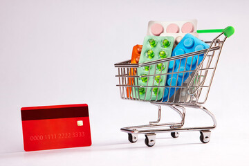 A credit card alongside a cart of medicines.