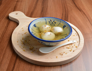 boiled glutinous rice ball (tang yuan) with peanut and sesame in sweet gui Hua flower soup dessert...