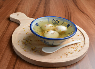 boiled glutinous rice ball (tang yuan) with peanut and sesame in sweet gui Hua flower soup dessert...