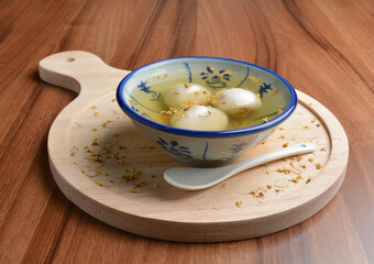 boiled glutinous rice ball (tang yuan) with peanut and sesame in sweet gui Hua flower soup dessert...
