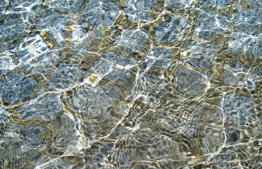 Fototapeta na wymiar Surface of the water with glittering reflection of light 