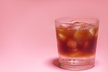Fototapeta na wymiar Iced coffee in a glass on pink background. Cold refreshment summer drink