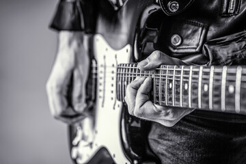 Electric guitar. Close up hand playing guitar. Musician playing guitar, live music. Black and white
