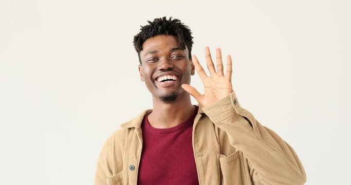 Happy man smiling and greeting by waving hand over white background