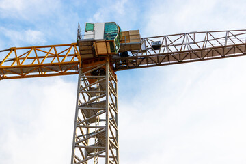 Tower crane close-up on a background of blue sky. Modern housing construction. Industrial engineering. Construction of mortgage housing.