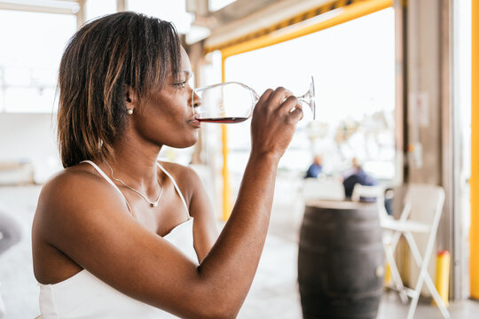 Sexy black woman drinking white wine