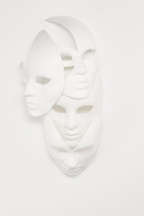 White venetian or theatrical masks of different shapes and types on a background. High key