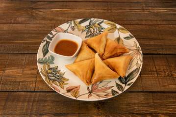 Porción de carne samosa cocida con receta oriental con salsa para mojar