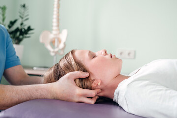 A girl receiving CST treatment by osteopath practitioner using gentle hands-on technique, central...