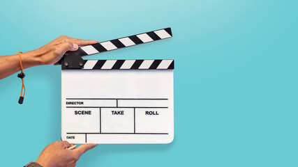 Hands with a movie clapperboard  on blue background