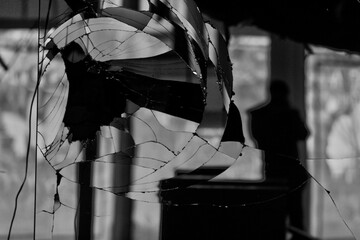 Fototapeta na wymiar silhouette du reflet d'un photographe dans une vitre cassé dans un magasin abandonné