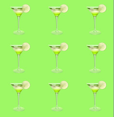Glasses of tasty martini cocktail on green background