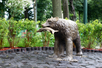 Park with a monument to the bear. Bronze statue of a bear with prey