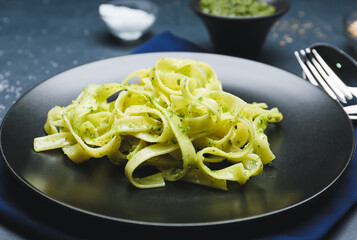 Plate with tasty pesto pasta on table