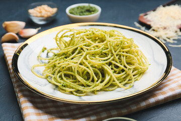 Plate with tasty pesto pasta on dark background
