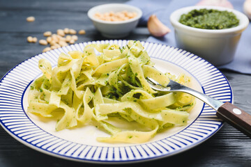Plate with tasty pesto pasta on table