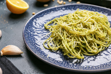 Plate with tasty pesto pasta on table
