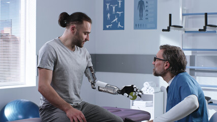 Doctor teaching patient to use prosthetic arm