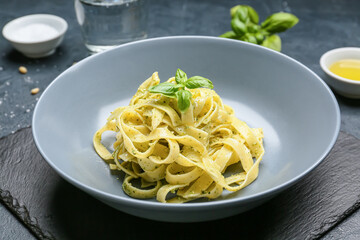 Plate with tasty pesto pasta on table