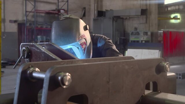 Soldador soldando pieza de metal 2