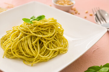 Plate with tasty pesto pasta on color background, closeup