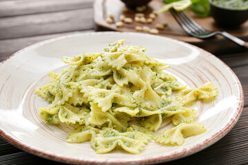 Plate with tasty pesto pasta on table