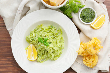 Plate with tasty pesto pasta on table