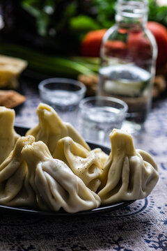 Georgian khinkali dumplings, bread and fresh salad with glasses of chacha