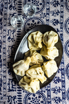 Fresh Georgian khinkali dumplings with glasses of chacha