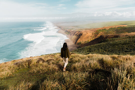 Female traveler on amazing seashore with endless cliffs and ocea