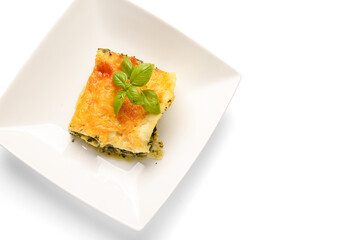 Plate with tasty green lasagna on white background
