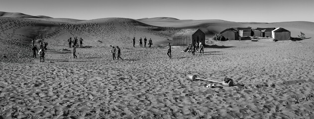 A group of people training in the desert, black and white - Powered by Adobe