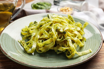 Plate with tasty pesto pasta on table