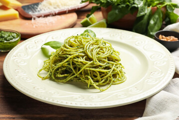 Plate with tasty pesto pasta on table