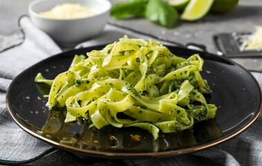 Plate with tasty pesto pasta on table