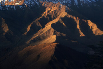 Nature scene - Aerial view of Snow Mountain and light of sunrise on the top  himalaya mountains from the plane at Leh Ladakh , Jammu and Kashmir , India - beautiful scene 