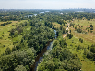 River among green trees in summer. Aerial drone view.