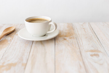 white coffee cup on wooden table with morning light