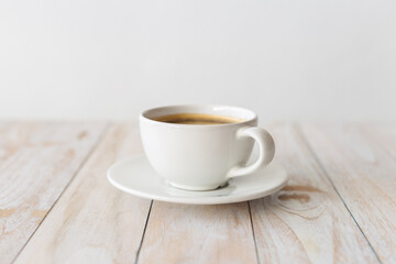 white coffee cup on wooden table with morning light